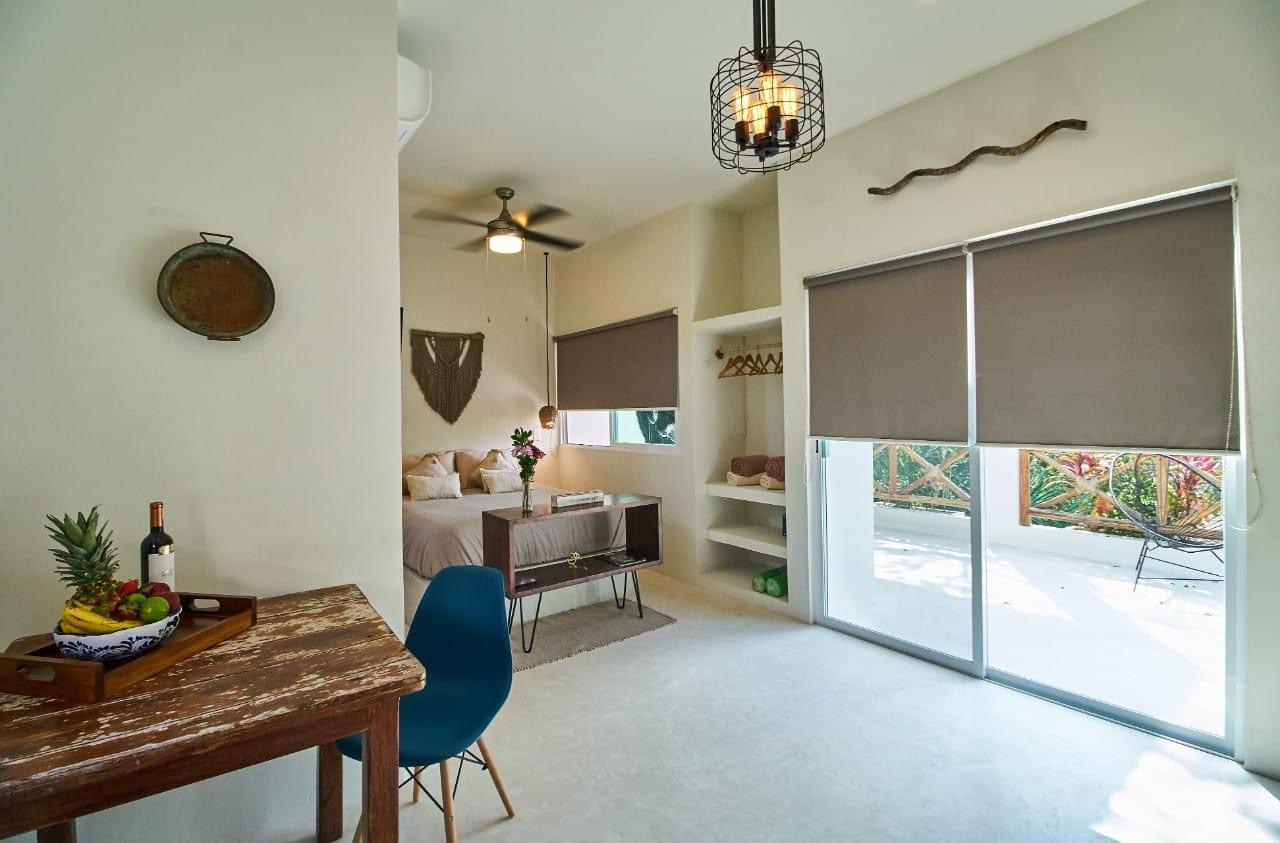 Studio interior with bed, fruit bowl, and terrace view